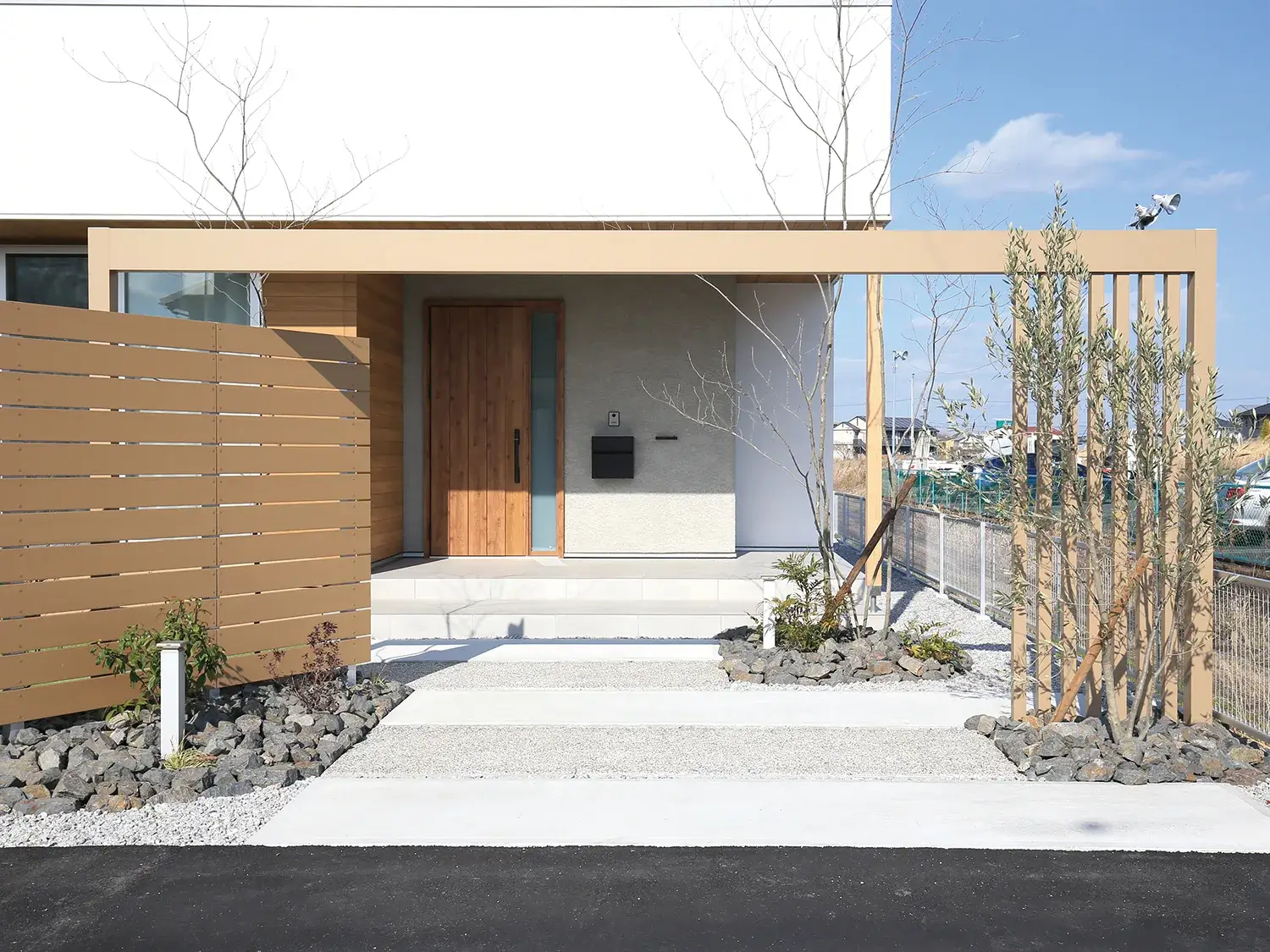 フェンスと調和する、ナチュラルな家の顔